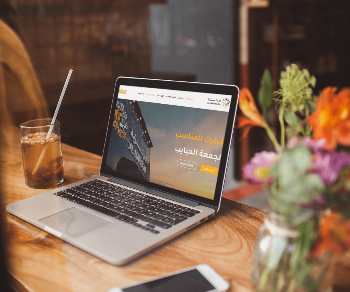 macbook mockup lying near a phone and some flowers a19515